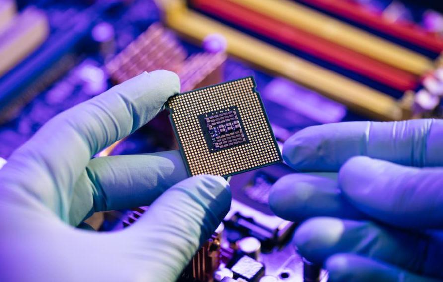 Laboratory technician holds a powerful processor in his hands. CPU computer processor shallow focus. CPU socket of the computer's motherboard. Concept of computer, motherboard, hardware and technology