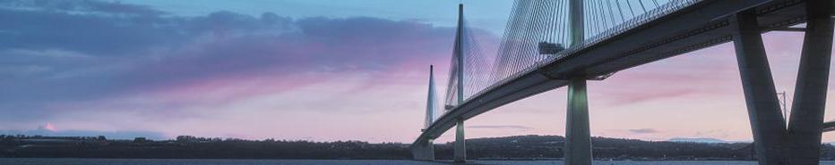 A view of a large three-tower cable-stayed bridge at sunrise. Queensferry Crossing Bridge, Scotland, United Kingdom